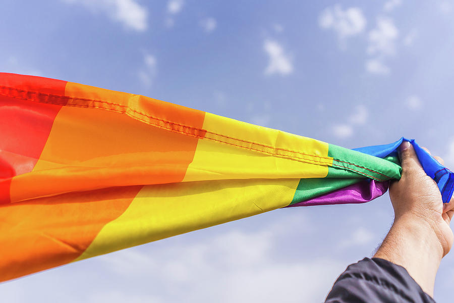 Hand Holding Colorful Lgbt Rainbow Flag In The Sky Photograph By Cavan