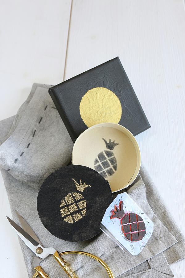Hand-made Foam Rubber Pineapple Stamp, Box With Stamped Motif And Printed Picture With Golden Circle Lying On Grey Cloth Photograph by Regina Hippel