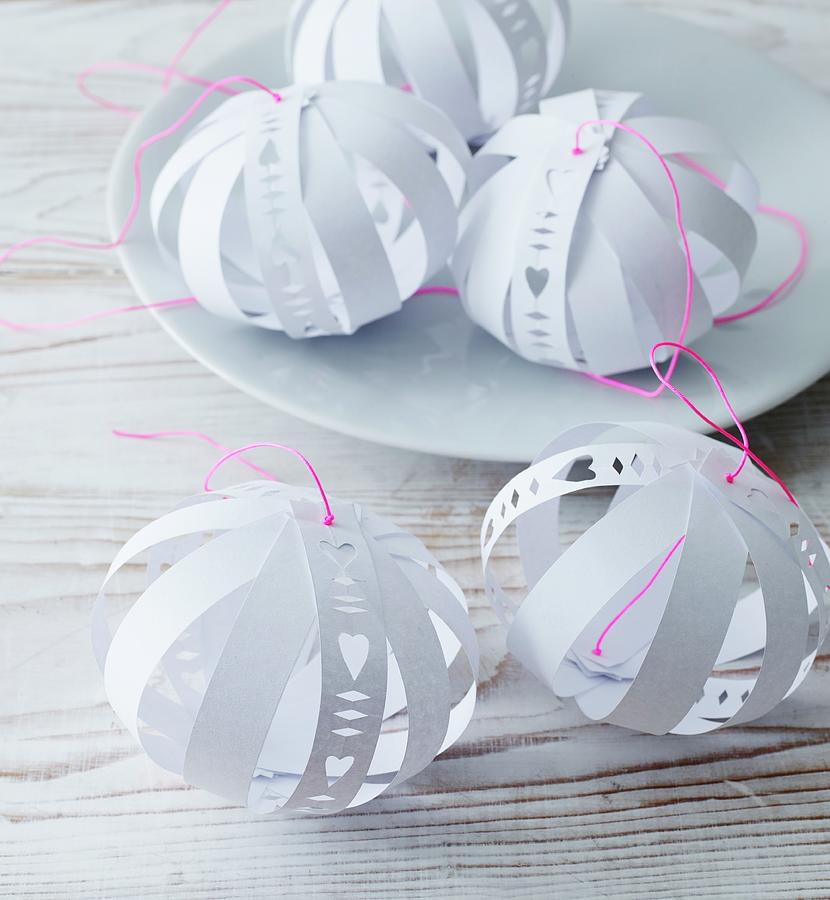 Hand-made, Paper Baubles With Cut-out Patterns And Bright Pink Cords Photograph by Andreas Hoernisch
