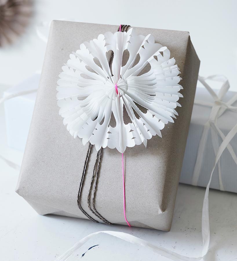 Hand-made, Pleated Paper Stars With Cut-out Patterns As Festive Decoration On Wrapped Gift Photograph by Andreas Hoernisch