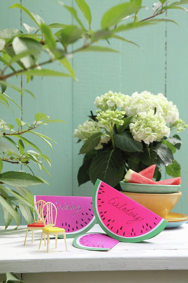 Hand-made, Watermelon-slice Invitation Cards Made From Folded Paper On Garden Table Photograph by Thordis Rggeberg