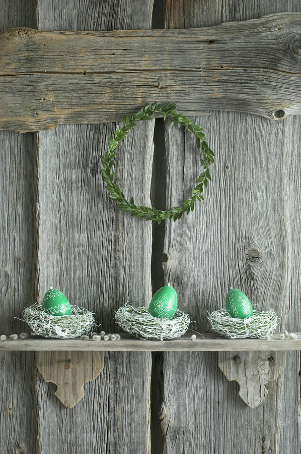 Hand-painted Easter Eggs In Willow Nests On Rustic Wooden Shelf Photograph by Achim Sass
