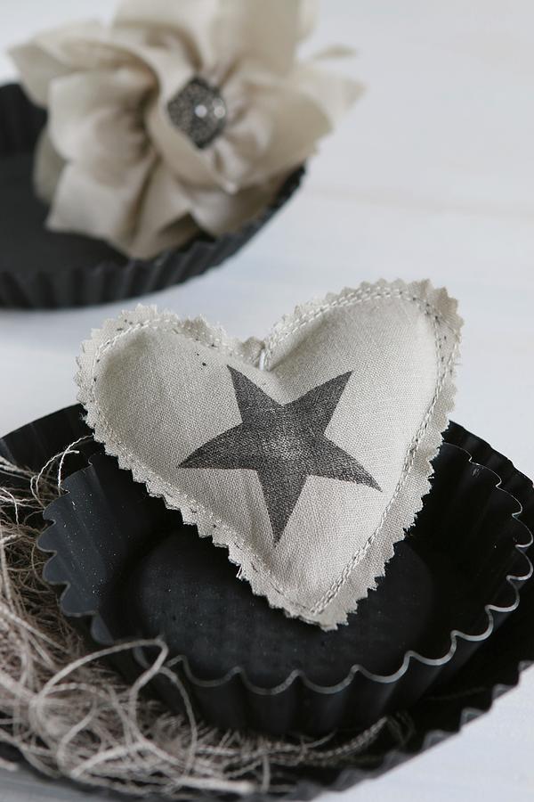 Hand-sewn Heart-shaped Cushion With Star Printed On Fabric Arranged In Black Cake Tin Photograph by Regina Hippel
