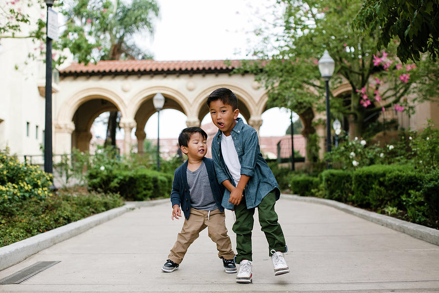 Architecture Photograph - Happy Brothers Dancing While Standing On Footpath At Balboa Park by Cavan Images