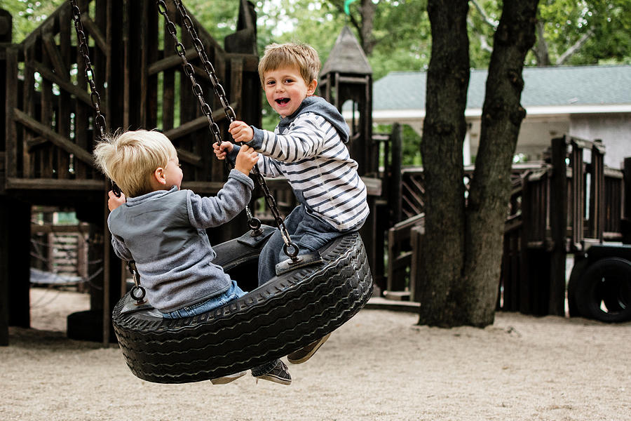 Tree Photograph - Happy Brothers Enjoying On Tire Swing In Playground by Cavan Images