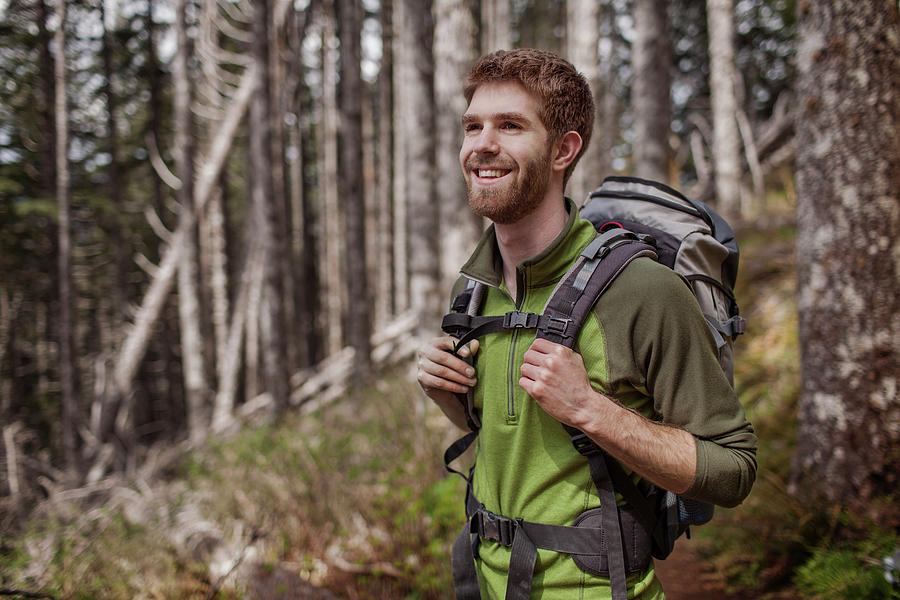 Happy Man Carrying Backpack While Standing In Forest Photograph by ...