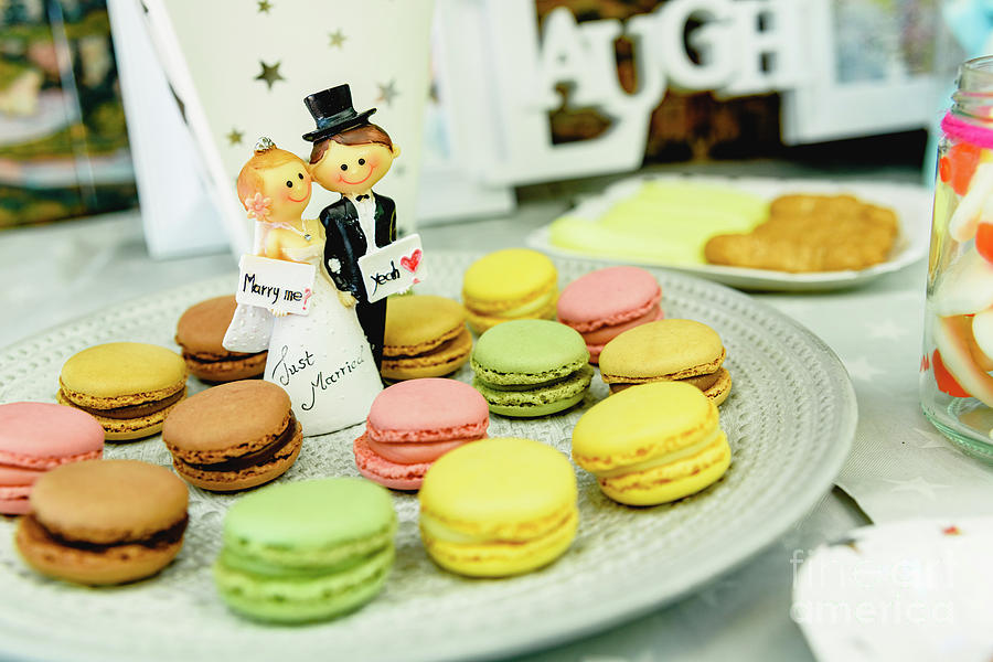 Happy newlywed dolls on a plate with macarons in the candy bar o Photograph by Joaquin Corbalan