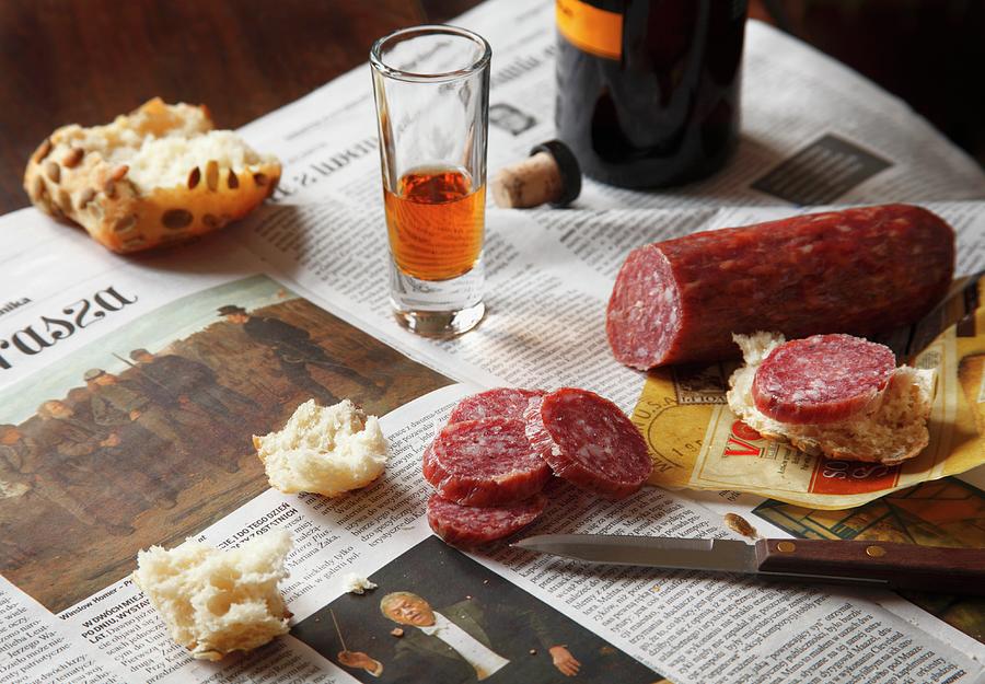 Hard Salami With Bread And A Glass Of Sherry On Polish Newspaper Photograph by Pollak, Katharine