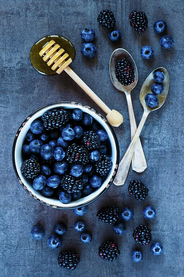 Harvest Background With Dark Berries In Vintage Spoons And Honey Over Grunge Table Photograph by Yuliya Gontar