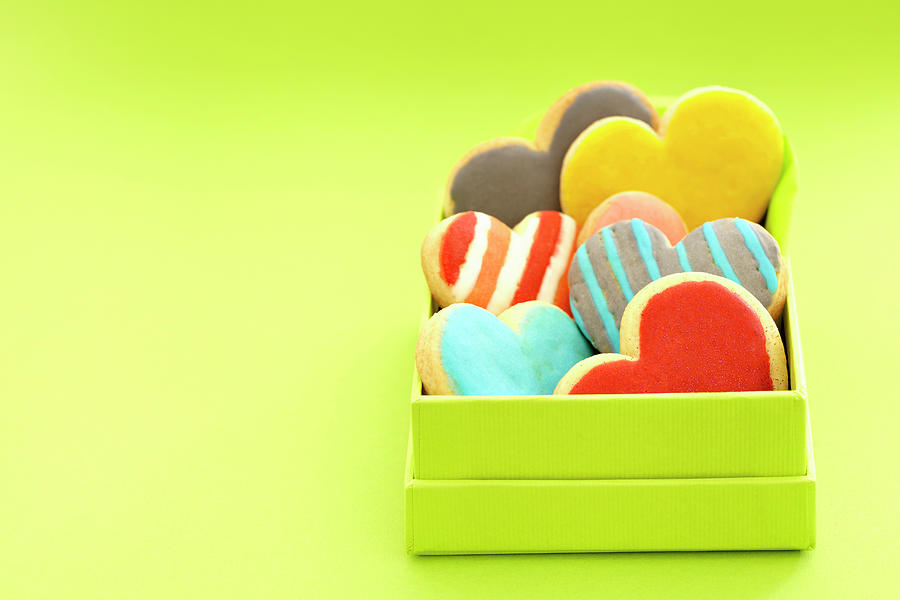 Heart Cookies With Colorful Icing In A Box In Front Of A Green Background Photograph by Werner / S. Brigitte