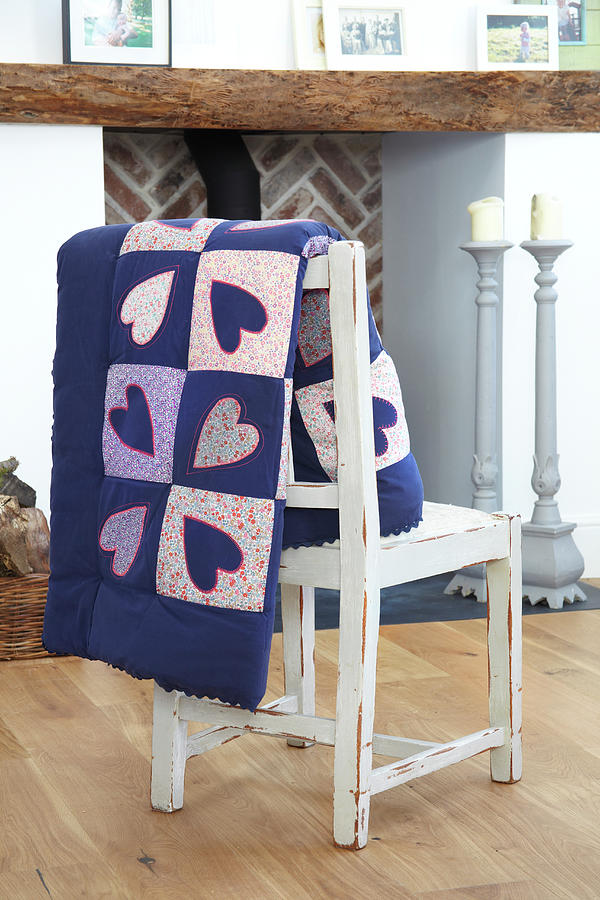 Heart-patterned Quilt Hung Over Chair Backrest Photograph by Simon Scarboro
