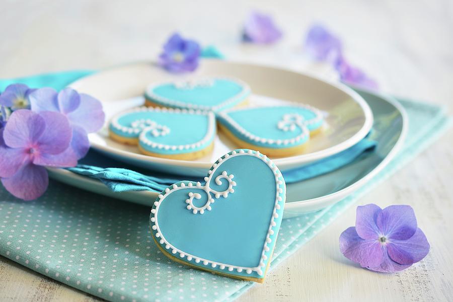 Heart-shaped Biscuits Decorated With Blue And White Icing Served On A Plate With Flowers Photograph by Mariola Streim