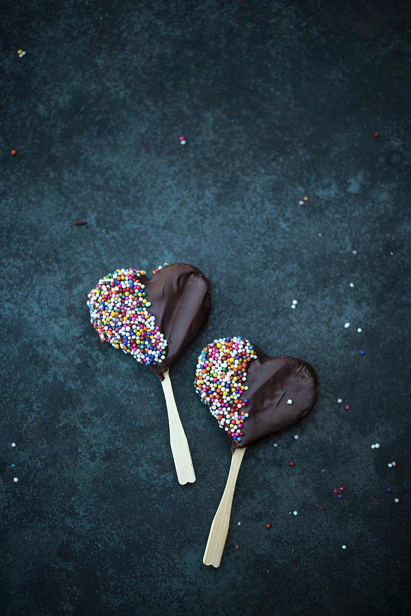 Heart-shaped Vegan Biscuits On Sticks Covered With Dark Chocolate And Sprinkles Photograph by Kati Neudert