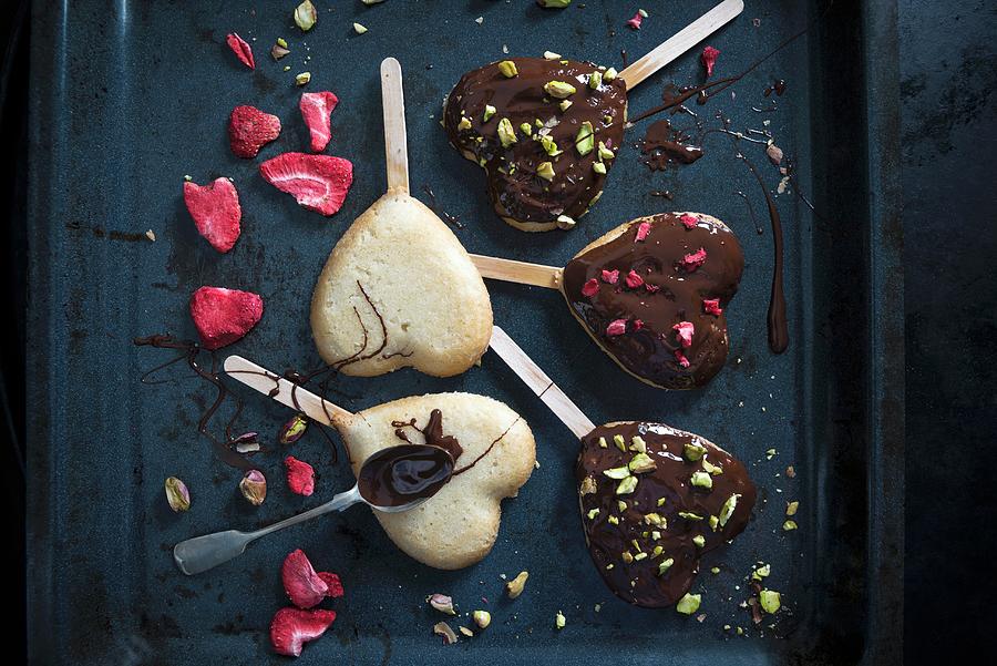 Heart Shaped Vegan Cakes On Sticks, Decorated With A Dark Beer Glaze, Freeze-dried Strawberries And Pistachios Photograph by Kati Neudert