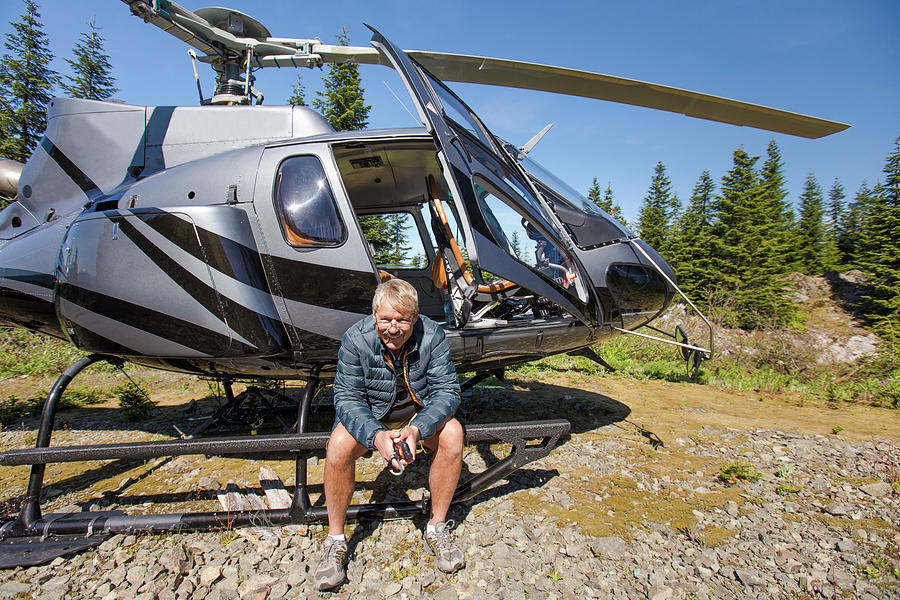 Transportation Photograph - Helicopter Pilot Waits For Clients In The Backcounty. by Cavan Images
