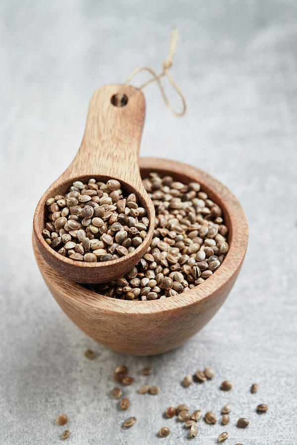 Hemp Seeds In A Wooden Bowl And A Wooden Scoop Photograph by Brigitte Sporrer
