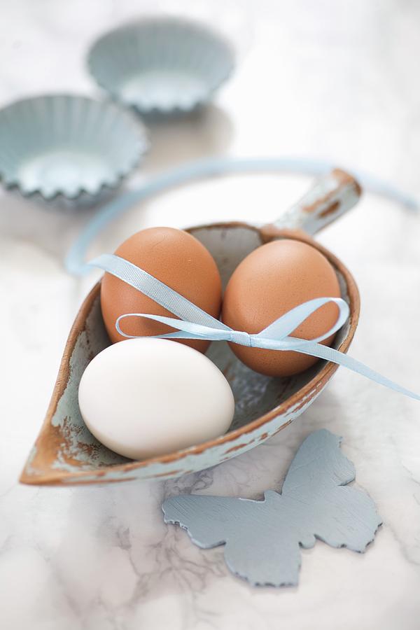 Hens Eggs With A Ribbon In A Small Wooden Scoop On A Marble Surface Photograph by Alicja Koll