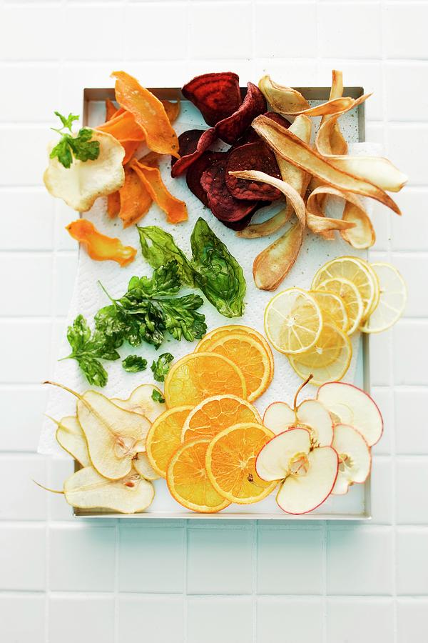 Herb Leaves, Vegetable Chips And Fruit Slices On A Tray seen From Above Photograph by Michael Wissing