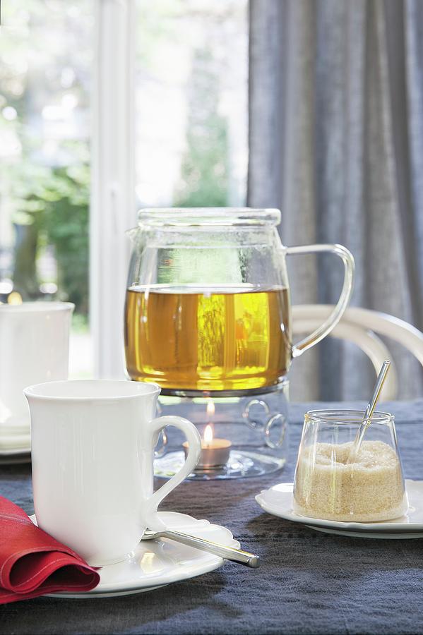 Herb Tea In A Glass Pot On A Warmer With A Sugar Pot And A Cup Photograph by Jalag / Veronika Stark
