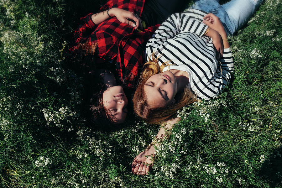 Nature Photograph - High Angle View Of Female Friends Napping On Grassy Field by Cavan Images