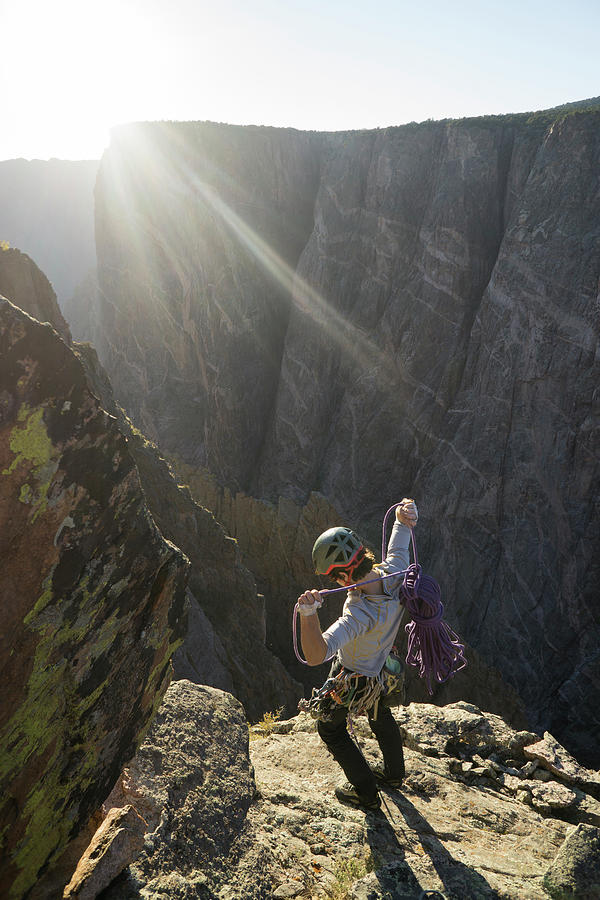 High Angle View Of Man With Rope Standing On Mountain Against Sky During Sunny Day Photograph by Cavan Images