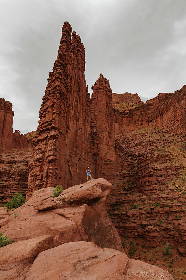 National Parks Photograph - Hiker Stands Under Fisher Towers On A Hike Outside Of Moab Utah by Cavan Images
