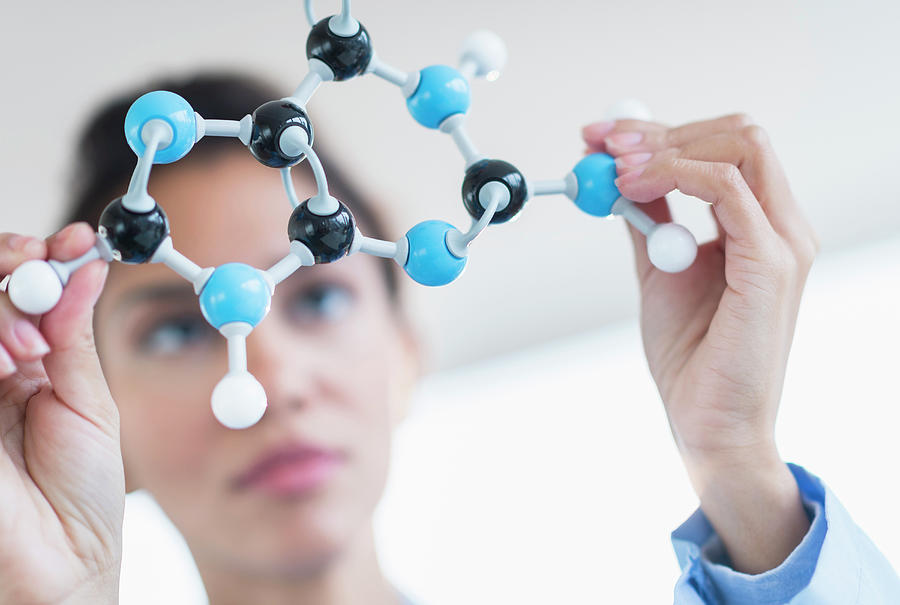 Hispanic Scientist Examining Molecular Photograph by Jgi/tom Grill