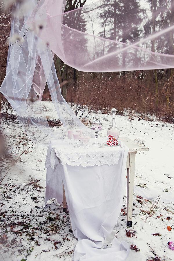 Home-made Raspberry Ice-cream On White Table With Floor-length Table Cloth Below Fluttering Chiffon Drapes Photograph by Maria Brinkop
