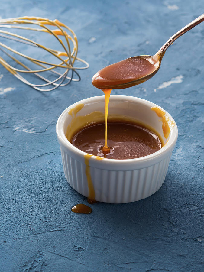 Home Made Salted Caramel In A Bowl Over Blue Background Photograph by Sofya Bolotina