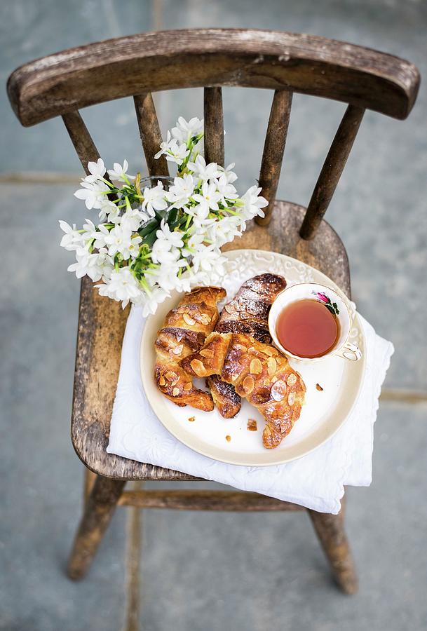 Homemade Almond Croissants With A Cup Of Tea On Rustic Chair Photograph by Lucy Parissi
