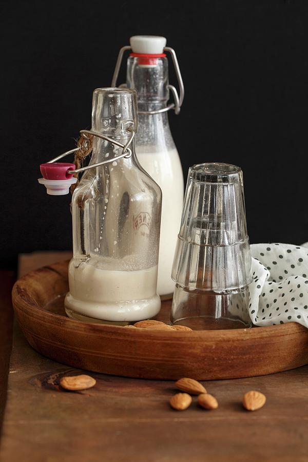 Homemade Almond Milk In Flip-top Bottles On A Wooden Tray Photograph by Sandhya Hariharan