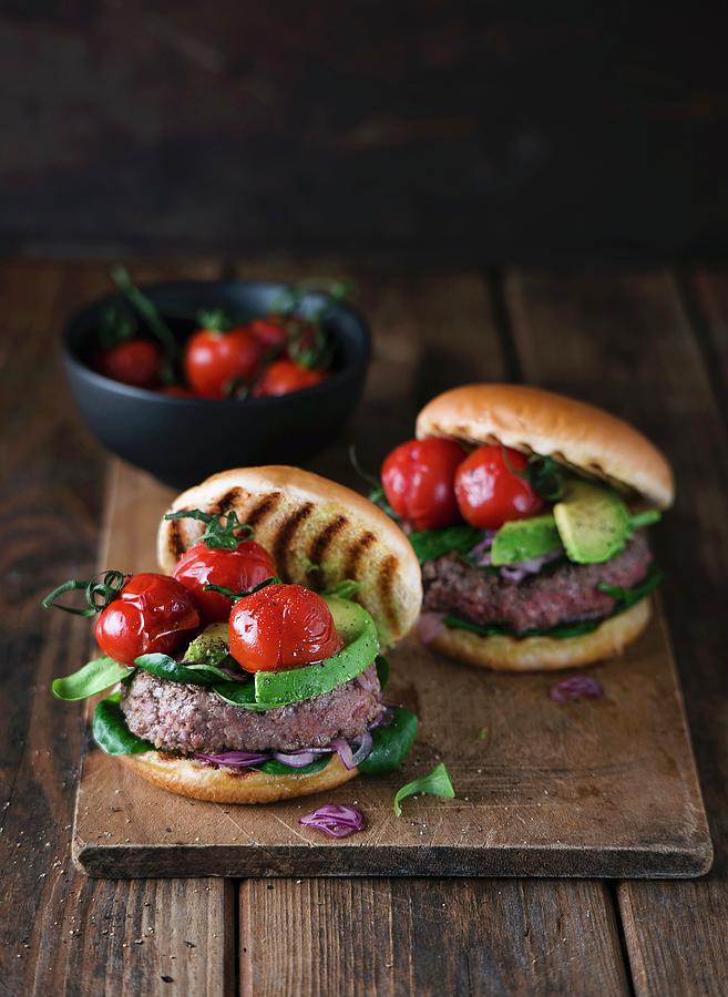 Homemade Burgers With Avocado And Cherry Tomatoes On A Wooden Board Photograph by Ewgenija Schall