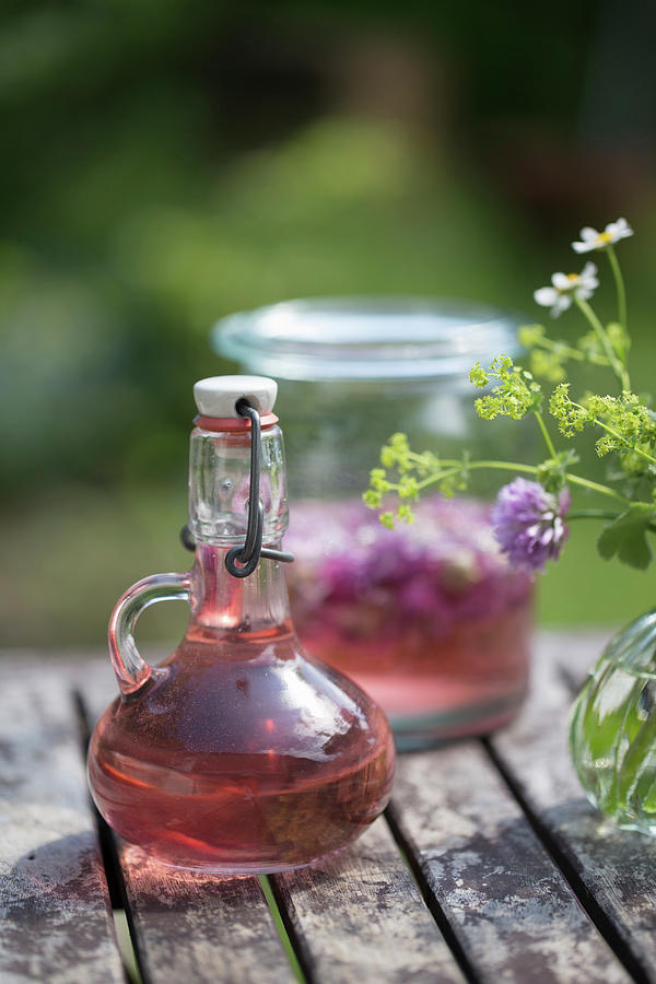 Homemade Chive-flower Vinegar In Decorative Carafe Photograph by Iris Wolf