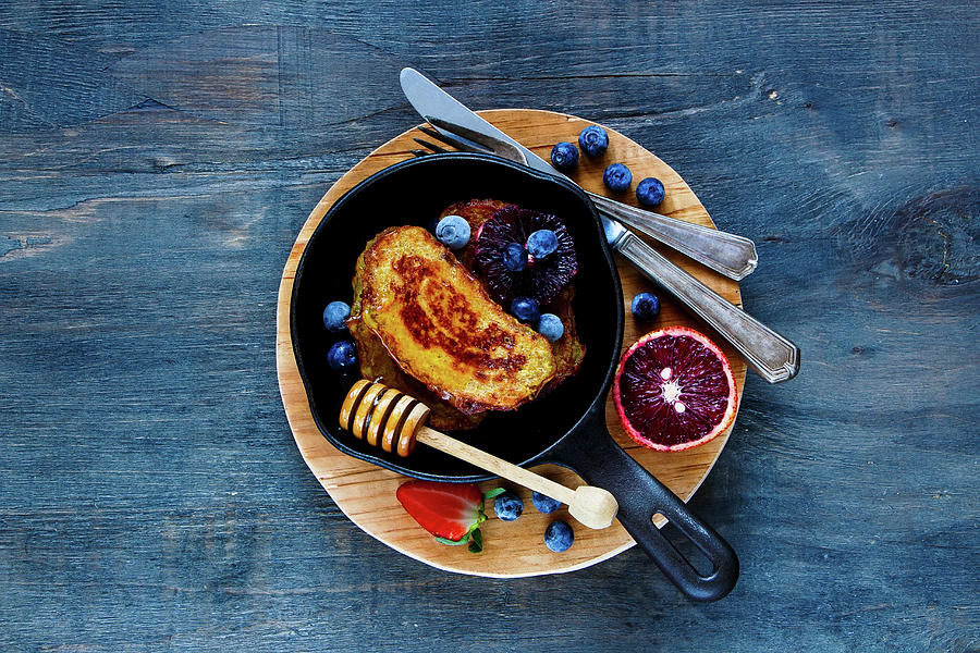 Homemade Cinnamon French Toasts With Honey, Berries And Bloody Orange In Vintage Cast Iron Pan For Breakfast On Rustic Wooden Background Photograph by Yuliya Gontar