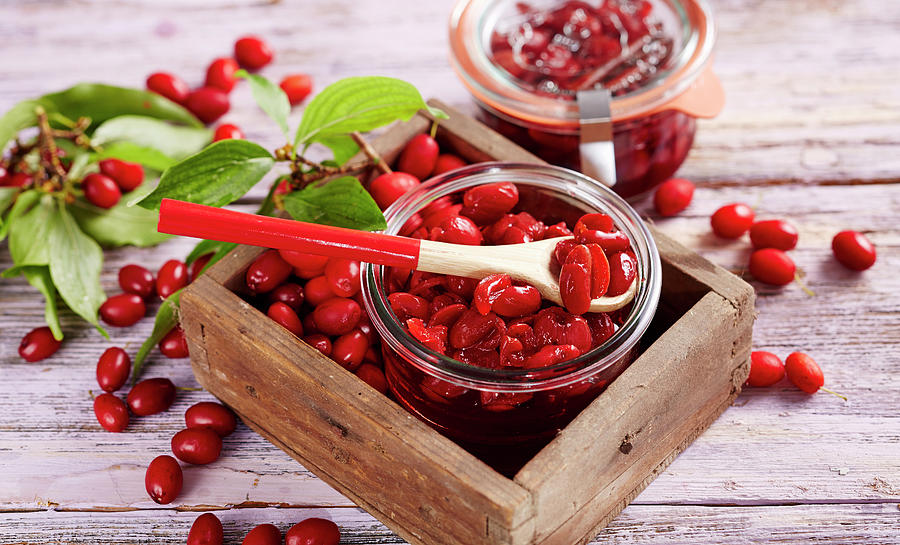 Homemade Cornelian Cherry Compote In A Glass On A Wooden Background Photograph by Teubner Foodfoto