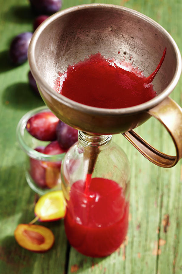Homemade Damson Syrup Being Poured Into A Bottle Using A Funnel Photograph by Teubner Foodfoto