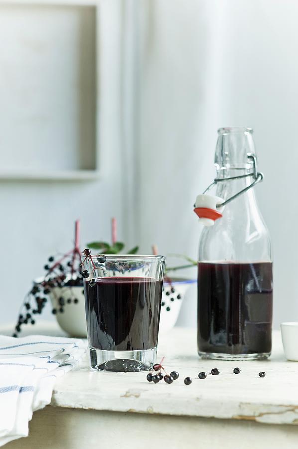 Homemade Elderberry Juice In A Bottle And A Glass Photograph by Achim Sass