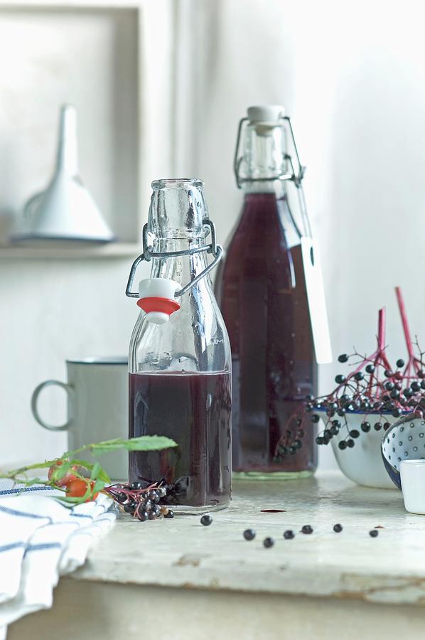 Homemade Elderberry Juice In Bottles Photograph by Achim Sass