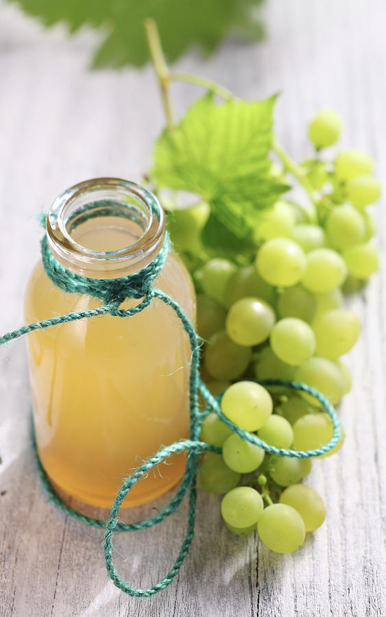 Homemade Grape Syrup In A Glass Bottle Next To Fresh Green Grapes Photograph by Teubner Foodfoto