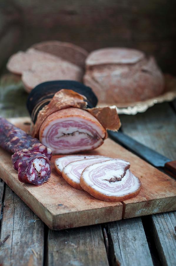 Homemade Hard Cured Sausage And Ham On A Chopping Board Photograph by Irina Meliukh
