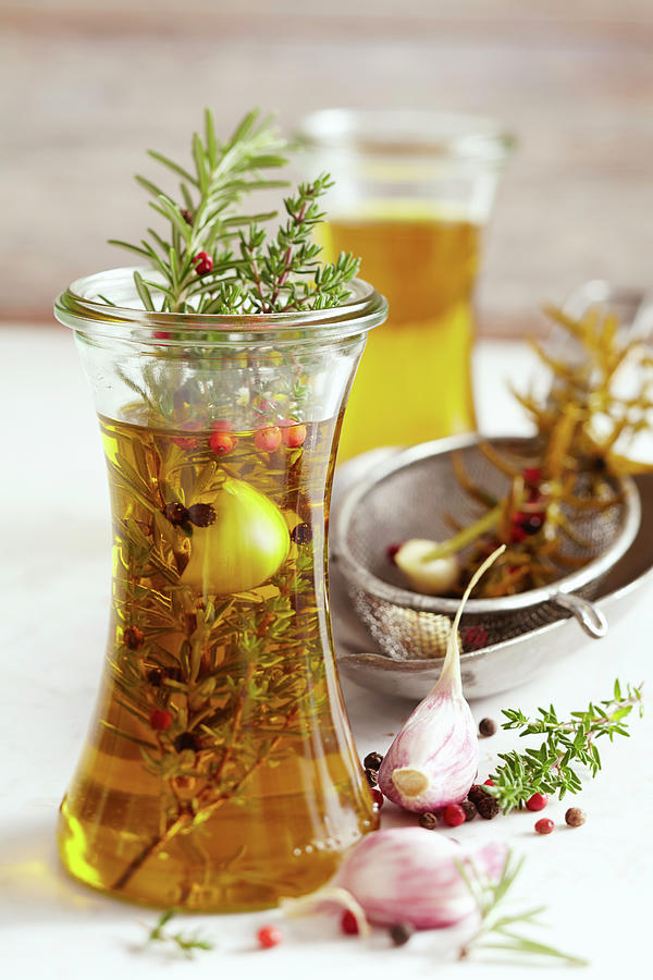 Homemade Herb Oil From South Africa With Pink Pepper, Garlic, Rosemary And Thyme Photograph by Teubner Foodfoto