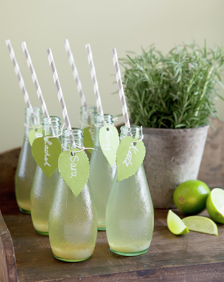 Homemade Lemonade In Small Bottles With Straws And Name Tags, Sliced Lime And Rosemary Photograph by Trudy Kelder