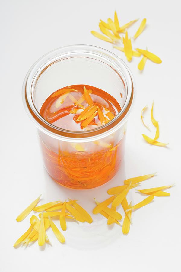 Homemade Marigold Oil Made From Thistle Oil And Marigold Petals Photograph by Sabine Lscher