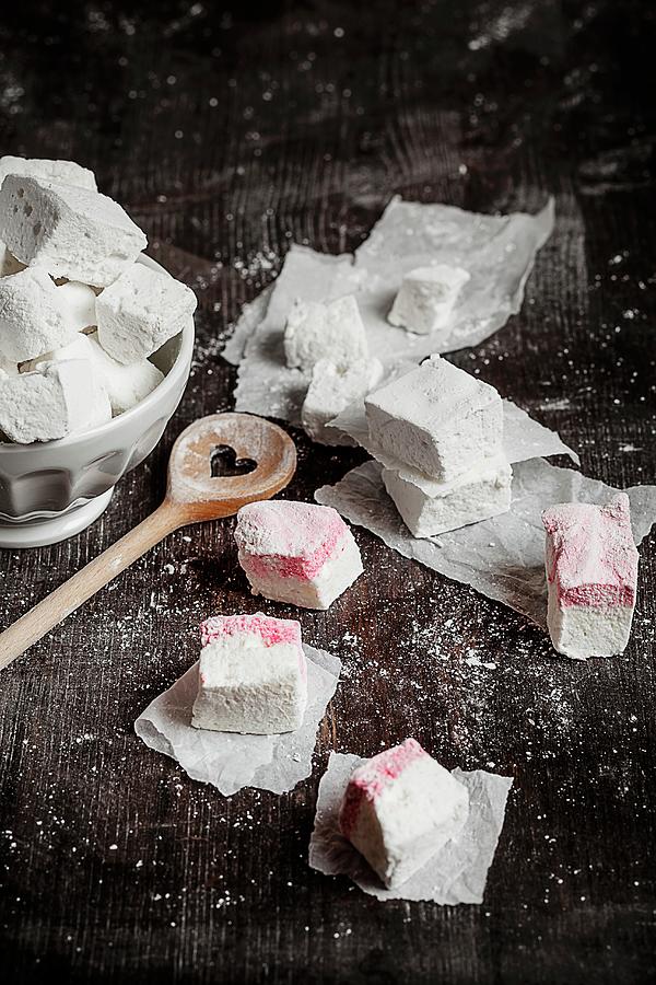 Homemade Marshmallows And Peppermint Marshmallows On A Wooden Surface With A Wooden Spoon Sprinkled With Icing Sugar Photograph by Susan Brooks-dammann