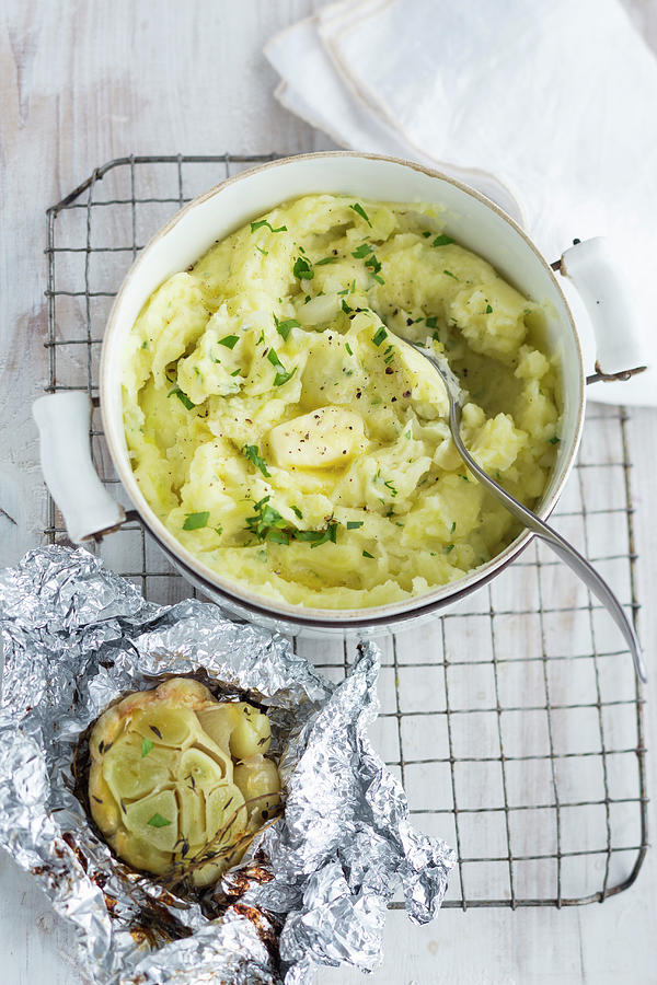 Homemade Mashed Potatoes With Butter In A Pot And Baked Garlic In Aluminium Foil Photograph by Eising Studio