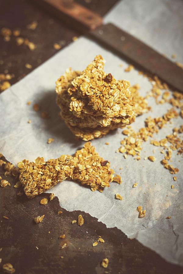 Homemade Muesli Bars On Baking Paper With A Knife Photograph by Riccardobruni