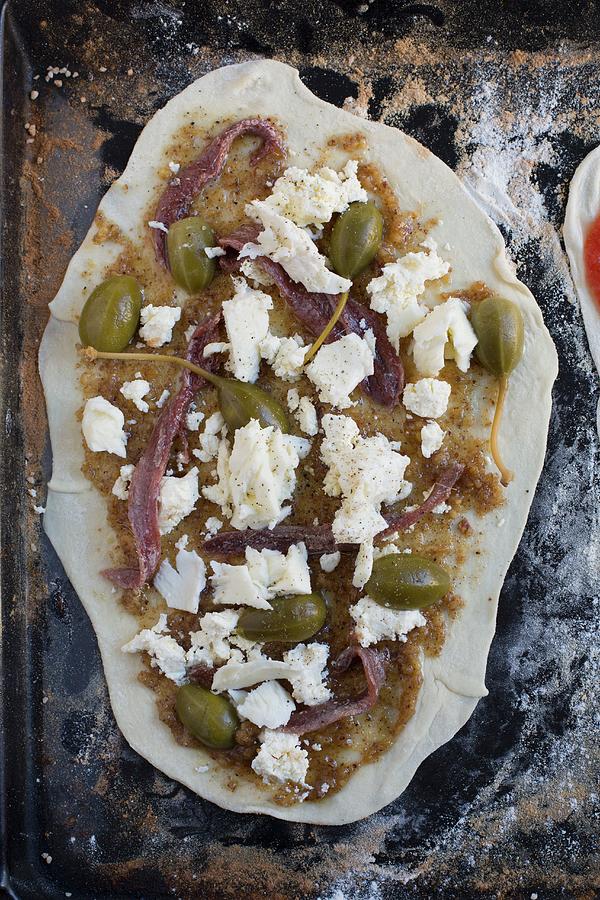 Homemade Pizza With Mozzarella, Caper Fruits, Walnut Pesto And Lemon Sardines On A Baking Tray unbaked Photograph by Tina Engel