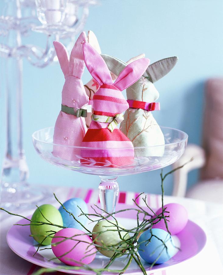Homemade Rabbit-shaped Egg Cosies And Coloured Eggs On A Glass Stand Photograph by Jalag / Gaby Zimmermann