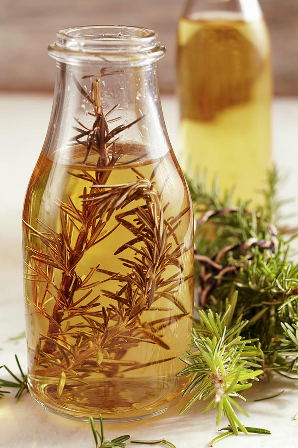 Homemade Rosemary Vinegar In A Glass Bottle Photograph by Teubner Foodfoto