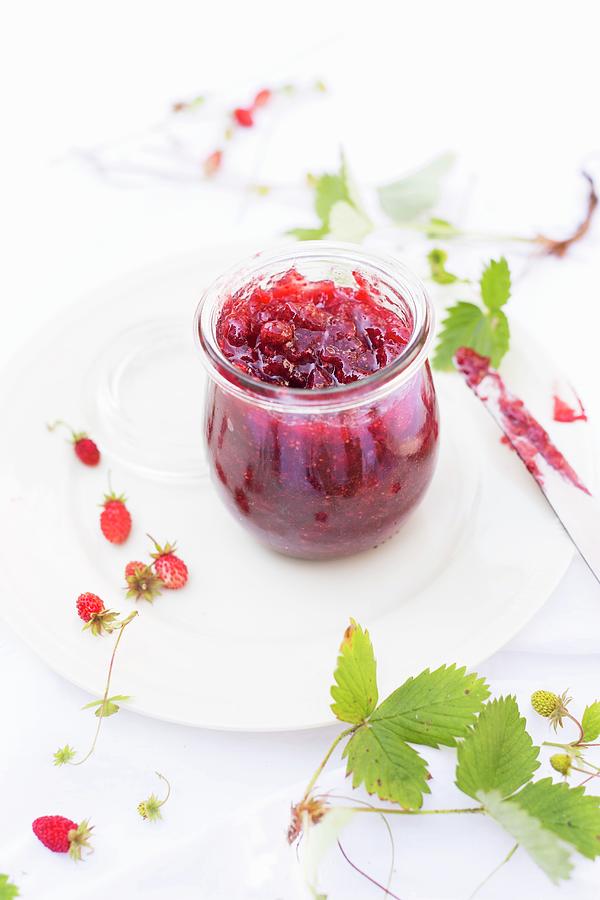 Homemade Wild Strawberry Jam In A Preserving Jar With Fresh Berries And Leaves Next To It Photograph by Sabine Lscher